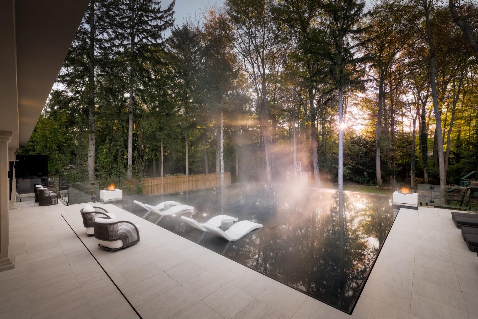 This poolside seating area has two square-shaped fire pits.